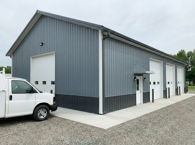 Indiana pole barn commercial facility by WVPFCO with gray metal siding, multiple garage bays, and white service van access